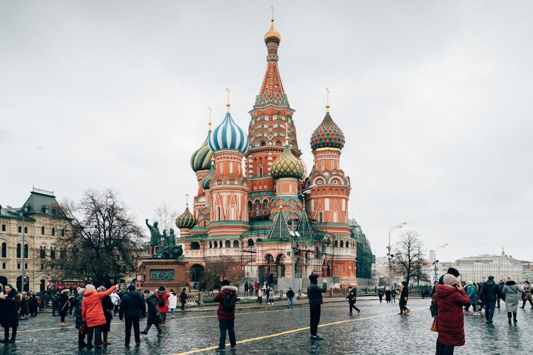 Toeristen voor de kleurrijke Sint-Basiliuskathedraal in Moskou